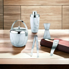 FNS 5-piece bar tool set with marble finish and stainless steel accents displayed on wooden table with brown book