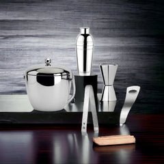 FNS bar tools arranged on rustic wooden board showing cocktail shaker, ice bucket, jigger, tongs, and opener in lifestyle setting