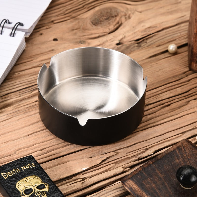 FNS black stainless steel ashtray on rustic wooden desk with notebook and drawer for home or office use