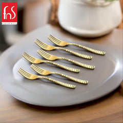 A set of six stainless steel dinner forks with black heads and geometric-patterned handles, arranged neatly on a white napkin surrounded by bowls of berries.
