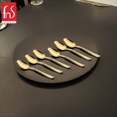 FNS Boston 6-piece gold dessert spoon set with ribbed handles elegantly arranged on black plate, showcasing luxurious mirror finish and premium stainless steel.