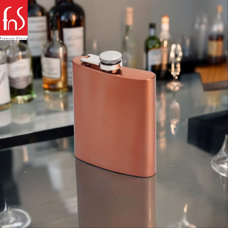 FNS Premium Dining copper finish hip flask with stainless steel screw cap on reflective bar counter with blurred liquor bottles in background