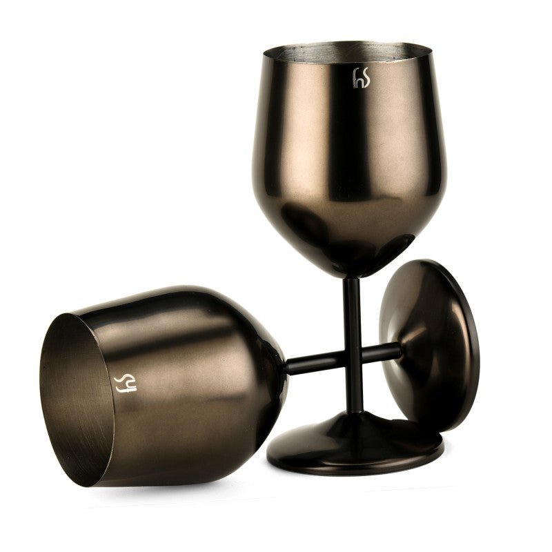 Two FNS black stainless steel wine glasses, one upright and one tilted on its side, showing interior brushed finish on white background