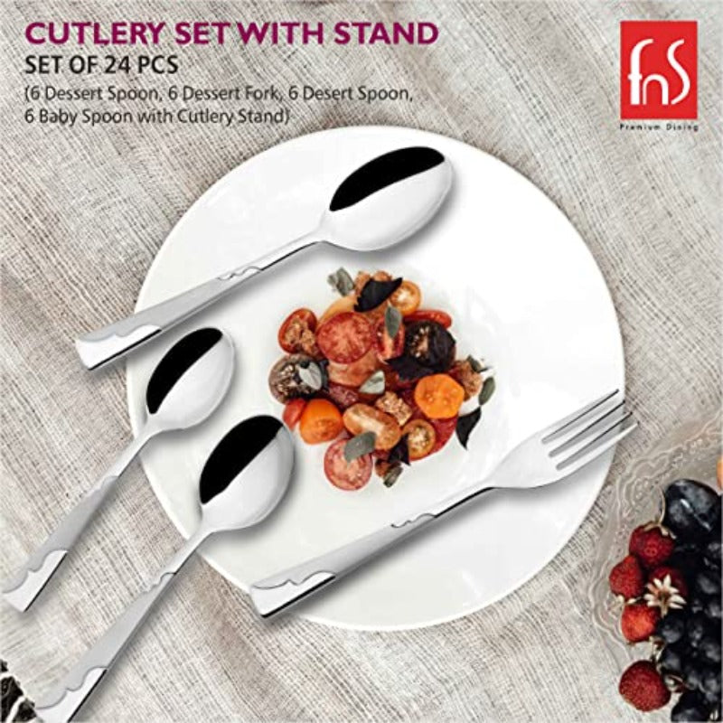 Elegant stainless steel cutlery displayed around a white plate with colorful salad on textured tablecloth.
