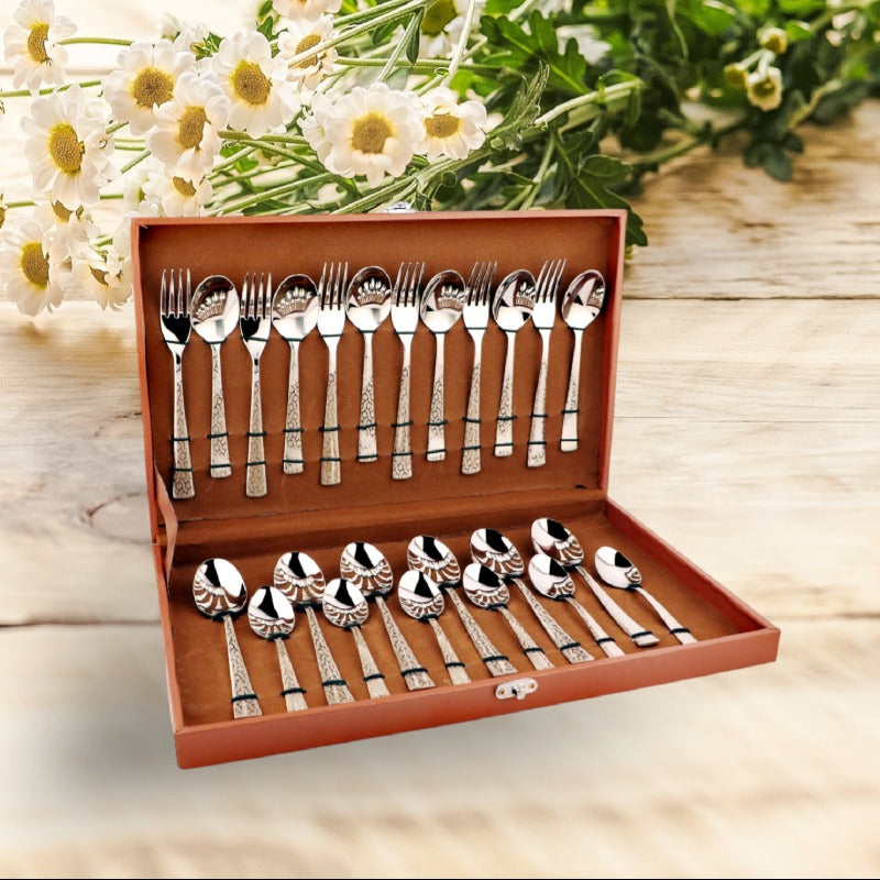 24-piece FNS cutlery set in a brown gift box, displayed on wooden table with flowers.