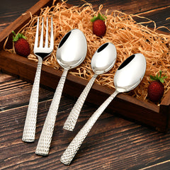 Decorative tray with fork and spoons featuring textured handles, surrounded by hay and fresh strawberries.