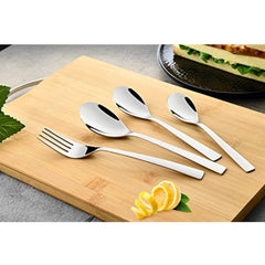 Stainless steel fork and spoons displayed on wooden board beside lemon slices and sandwich plate.