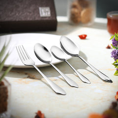 Polished fork and spoons placed beside a white plate on a table with floral decor.