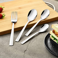 Fork and spoons arranged on wooden board, beside black plate of sandwich and strawberries.