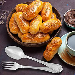 Fork and spoon beside bowl of sesame bread rolls, cup of coffee, and chocolate pieces.