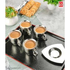 Set of 4 fns double wall stainless steel tea cups with triangular saucers filled with chai, styled on a black tray with biscuits and succulents in the background