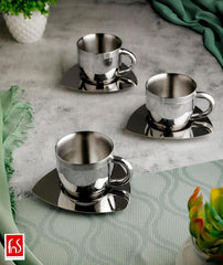 Three fns double wall stainless steel tea cups on triangular saucers styled on grey marble surface with green fabric and succulent plants