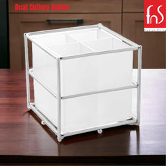Square white cutlery holder with steel frame placed on wooden countertop; FNS logo in corner.