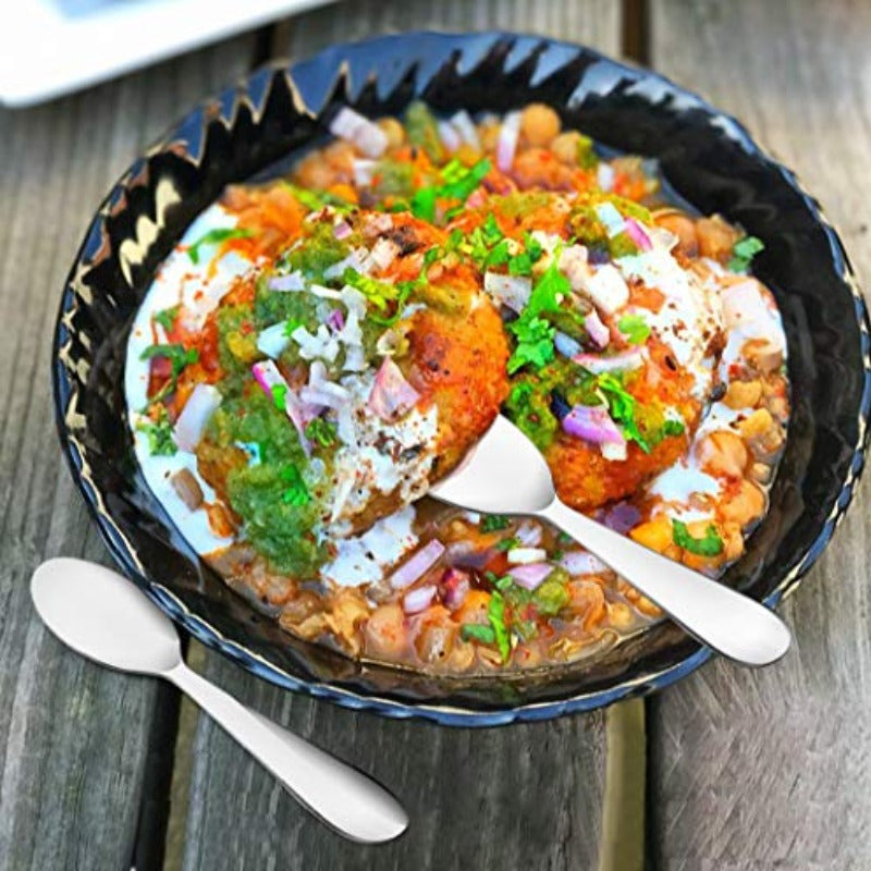 FNS Especials 6-piece chat spoon set serving colorful Indian street food with chickpeas, yogurt, chutney, and toppings on decorative black plate outdoors.