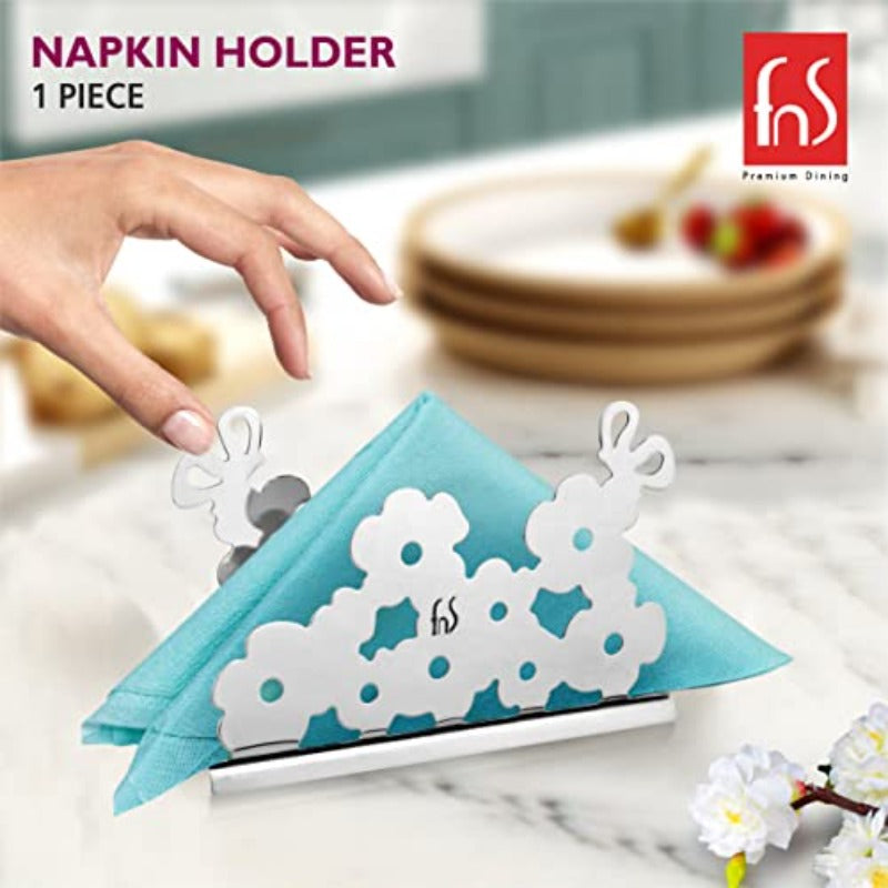 Hand picking a teal napkin from FNS Premium Dining floral stainless steel napkin holder on a marble kitchen countertop
