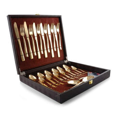 Elegant gold cutlery set arranged in a velvet-lined black presentation box with knives, forks, and spoons.