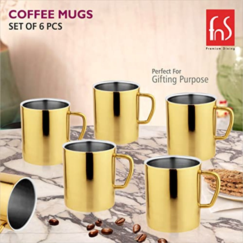 FNS Premium Dining set of 6 gold mirror finish stainless steel coffee mugs arranged on a marble table with coffee beans and biscuits, perfect for gifting