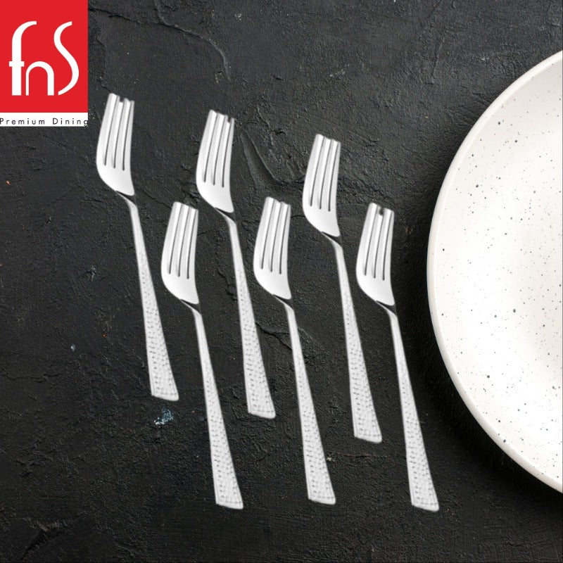 Six stainless steel dinner forks with dotted textured handles on dark slate surface