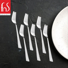 Six stainless steel dinner forks with dotted textured handles on dark slate surface