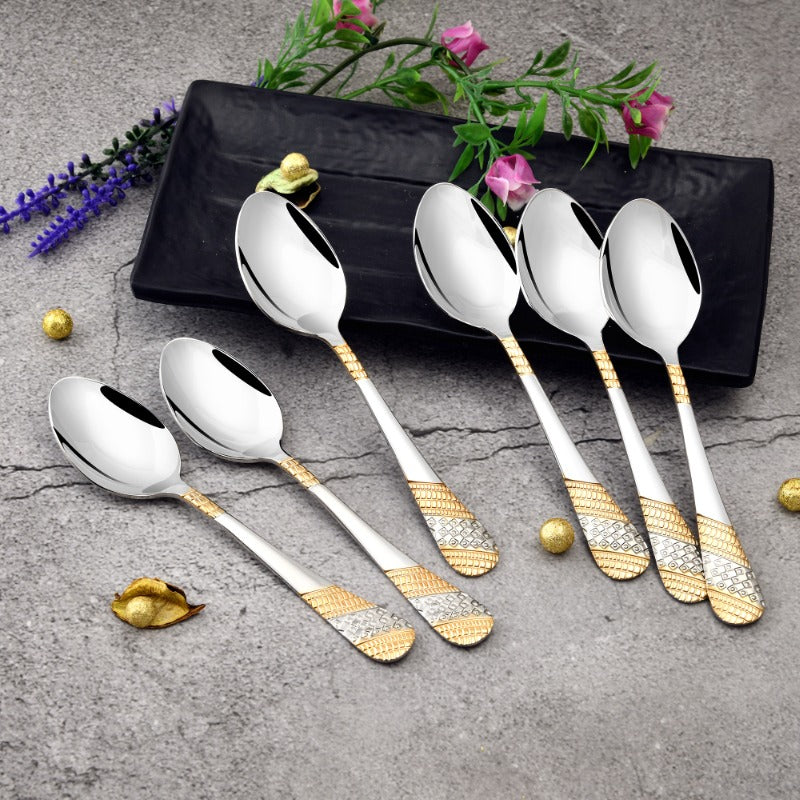 FNS Imperio 6 piece baby spoon set with 24 karat gold and silver plated geometric textured handles displayed on black tray with flowers and beads