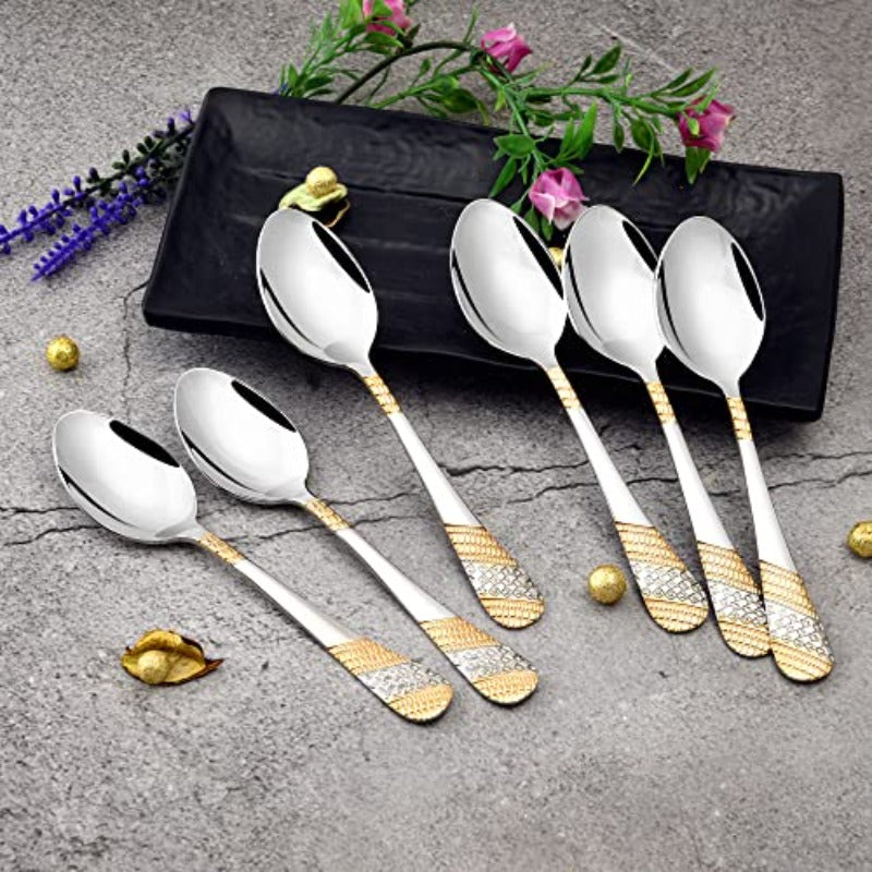 FNS Imperio 6 piece dinner spoon set with 24 karat gold plated textured handles displayed on black tray with fresh flowers