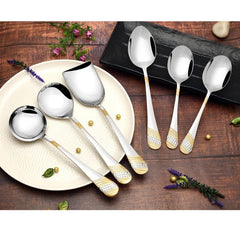 FNS Imperio 6-piece gold-plated serving spoon set displayed on rustic wooden table with lavender flowers, plates, and black tray, showcasing elegant textured handles.