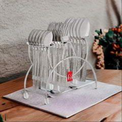 Textured stainless steel cutlery set organized neatly in a stylish silver stand on a wooden table.