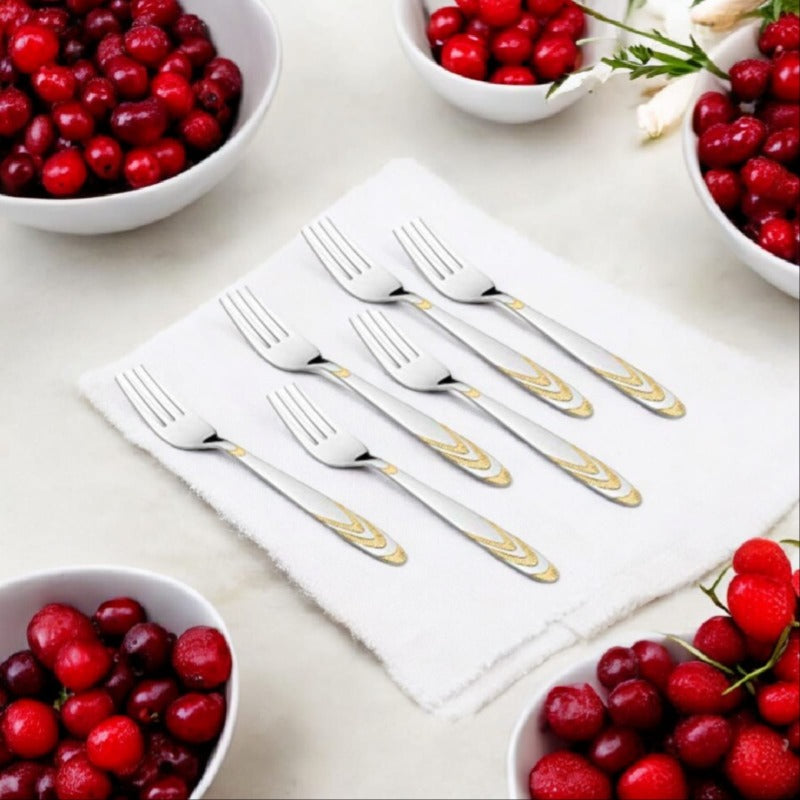 Six stainless steel dinner forks with gold decorative handles surrounded by cranberry bowls