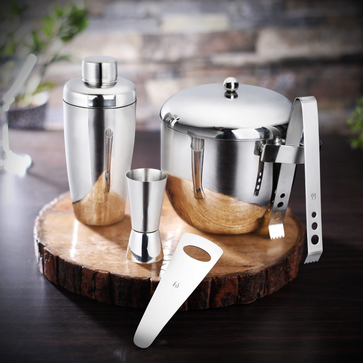 FNS Premium Dining 5-piece bar tool set with ice bucket, cocktail shaker, jigger, tongs, and bottle opener on dark wood surface