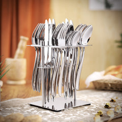 Full 24-piece polished cutlery set in holder, styled on decorative table with warm indoor background.