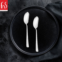 FNS Premium Dining stainless steel dinner spoons with textured handles on black plate, elegant table setting