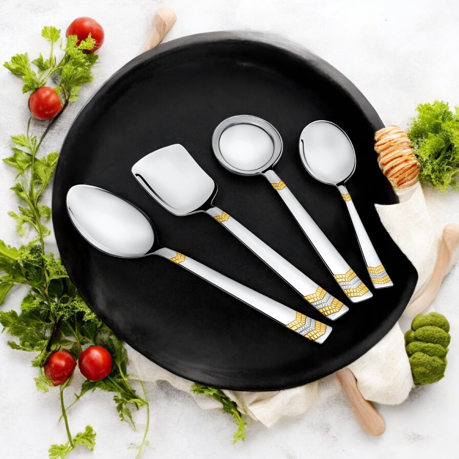 FNS Raga 4-piece serving set with 24-karat gold plated accents on black plate with fresh tomatoes, herbs, and vegetables lifestyle setting