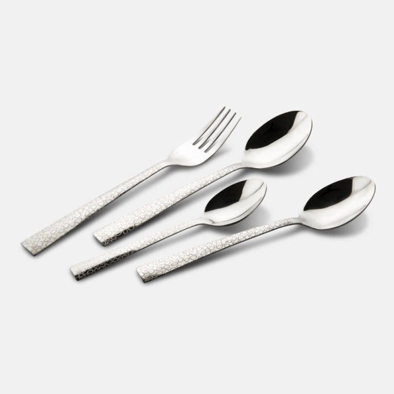 Knife, fork, and two spoons with engraved silver handles placed neatly on a plain grey background.