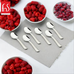 FNS Rhombo 6-piece stainless steel dinner spoon set with textured diamond pattern handles displayed with fresh raspberries and berries on gray surface.