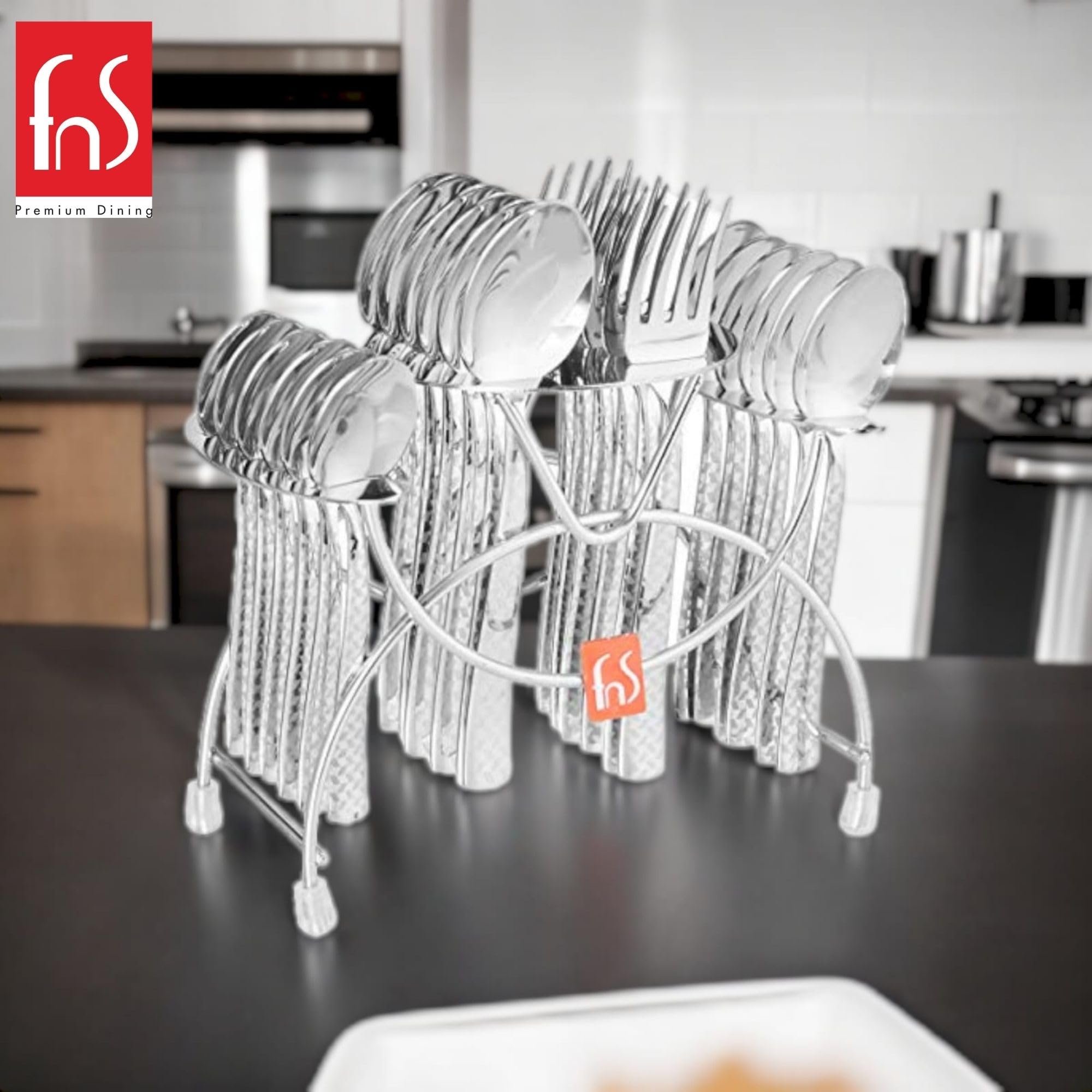 Shiny cutlery set with geometric handles in hanging stand displayed on black countertop in modern kitchen.