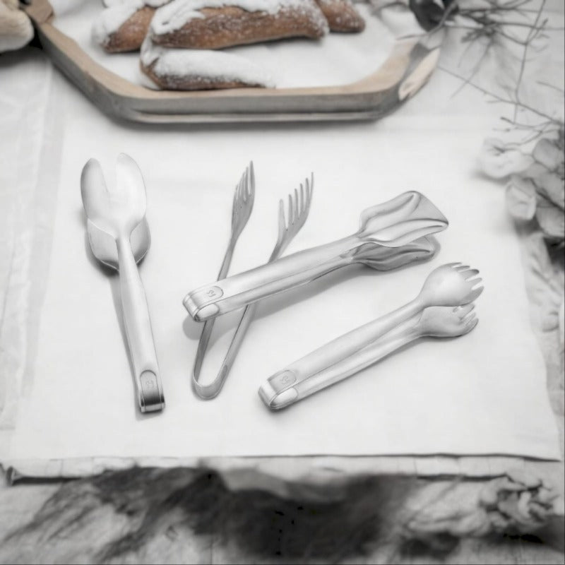 fns multiutility stainless steel tong set four piece ice tong spaghetti tong pastry tong salad tong displayed on white surface with bread platter