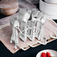 Stainless steel cutlery set neatly arranged in a silver stand, placed on textured kitchen cloth.