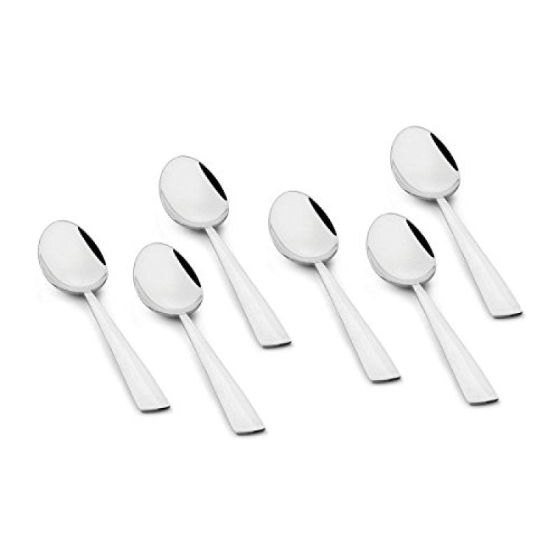 Six mirror-polished stainless steel teaspoons with angled flat handles arranged in scattered formation on white background showing modern minimalist design