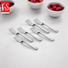 Six stainless steel dinner forks arranged on white surface with berry bowls nearbyRetry