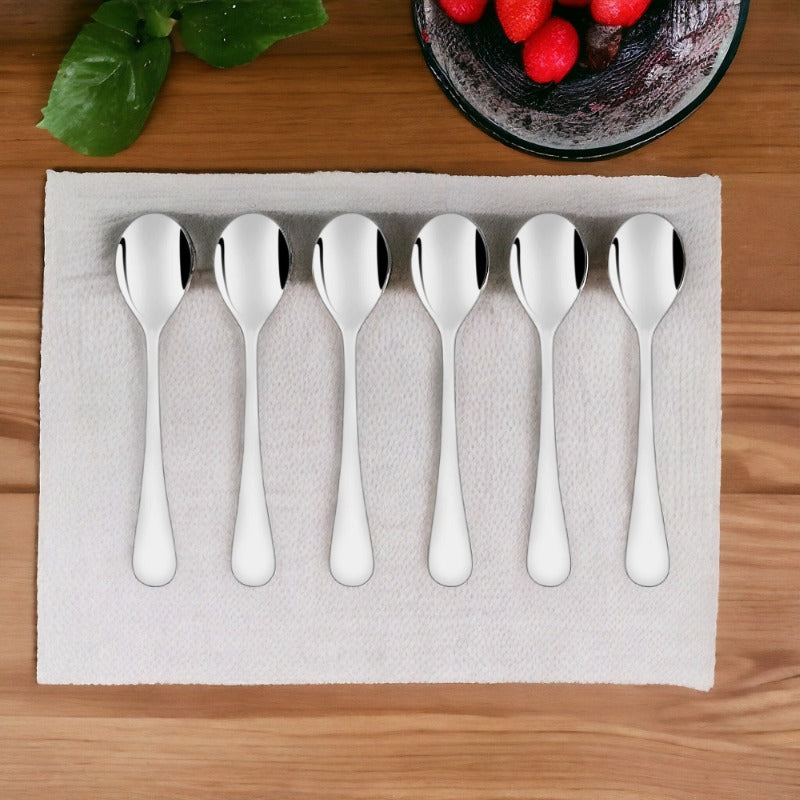 FNS Victoria 6 piece stainless steel baby spoon set with rounded handles arranged on white napkin beside wooden table with fresh strawberries