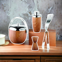 FNS wood finish bar tool set with ice bucket, cocktail shaker, jigger, tongs, and bottle opener displayed on wooden table against concrete wall