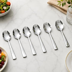 Montavo by FnS Milan 6-piece stainless steel spork set arranged on a marble dining table with fresh salad and fruits.
