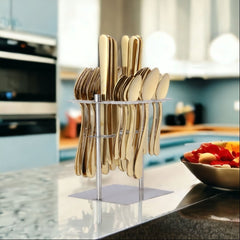 Gold cutlery set neatly arranged in a vertical stand on a modern kitchen countertop.
