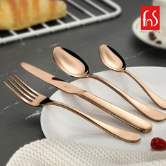 Glossy rose gold knife, fork, spoon, and teaspoon placed on white plate for premium table setting.
