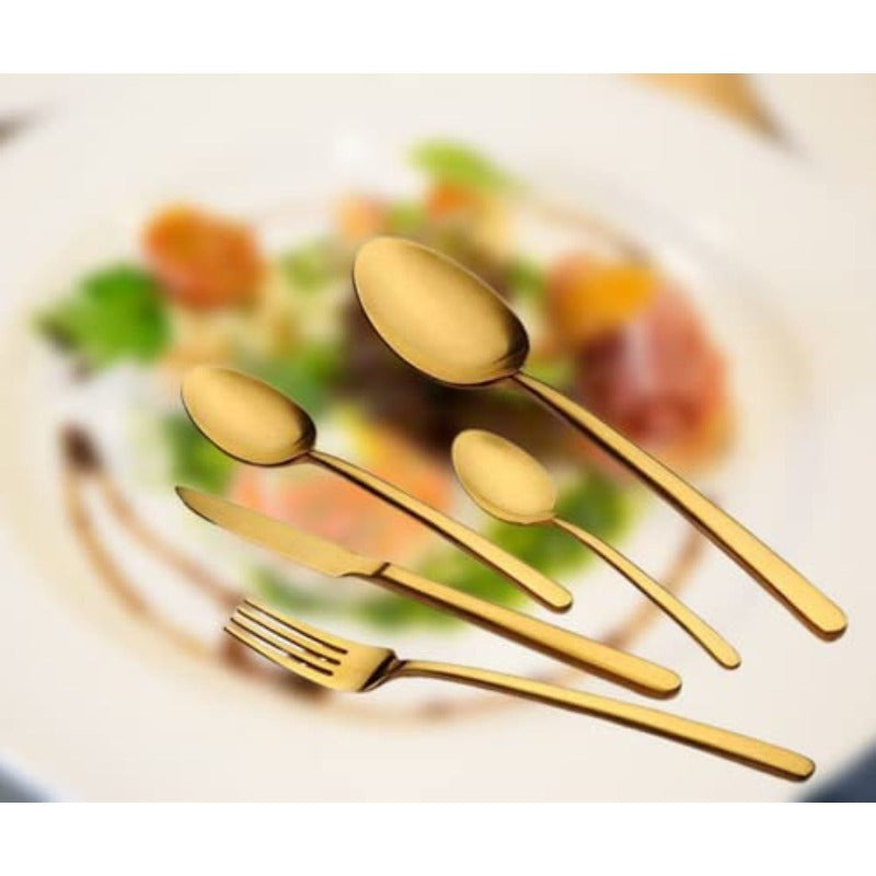 Five-piece gold cutlery set displayed over a blurred gourmet dish with vibrant colors in background.