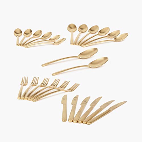 Full gold cutlery set spread out neatly, including spoons, forks, and knives in matching finish.
