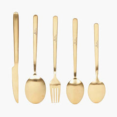 Five gold utensils including knife, spoon, and fork aligned upright against a clean white backdrop.
