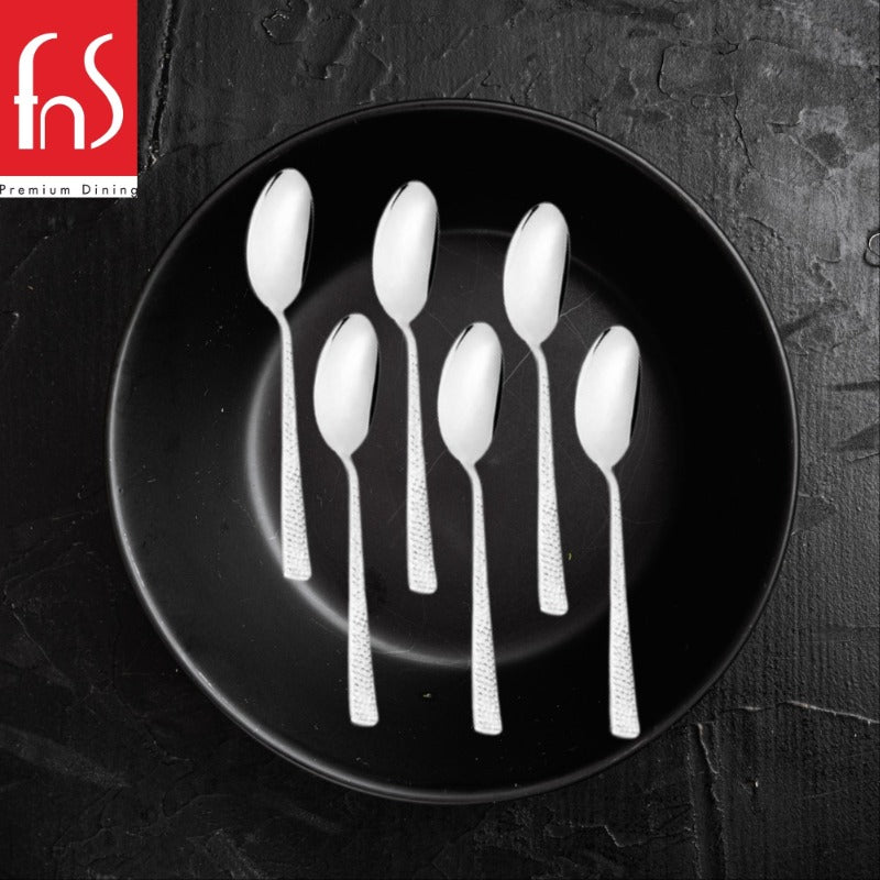 FNS Helios baby spoons with distinctive textured handles arranged on black round plate, modern flatware design for babies