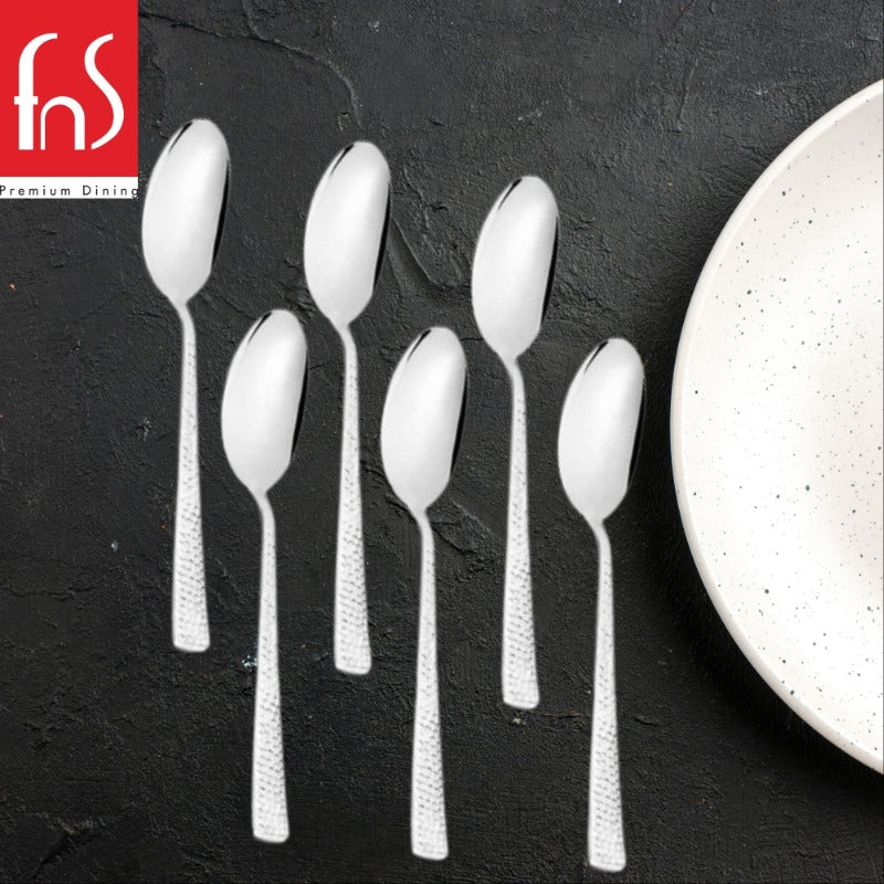 Six Helios stainless steel dessert spoons with distinctive textured handles arranged on white background, modern flatware design