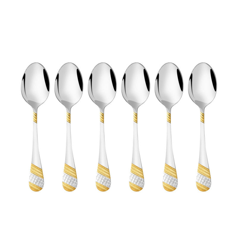 Six Imperio baby spoons featuring mirror polished stainless steel bowls with luxurious 24K gold and silver plated geometric pattern handles arranged on white